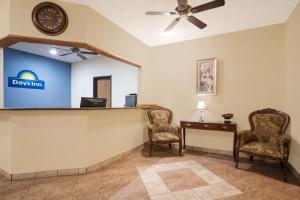 a waiting room with a desk and chairs and a clock at Days Inn by Wyndham Mankato in Mankato