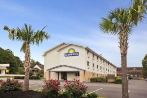a hotel with palm trees in a parking lot at Days Inn by Wyndham Greenwood SC in Greenwood