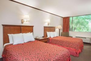 una camera d'albergo con due letti e una finestra di The Schenectady Inn & Suites a Schenectady