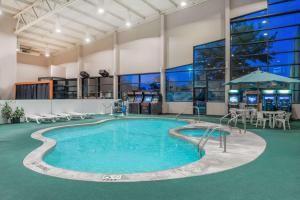 una piscina con mesas y sillas en un edificio en Days Inn by Wyndham Kirksville, en Kirksville