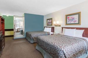 a hotel room with two beds and a mirror at Days Inn by Wyndham Camarillo - Ventura in Camarillo