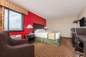 Habitación de hotel con cama y TV en Days Inn by Wyndham Muncie -Ball State University, en Muncie