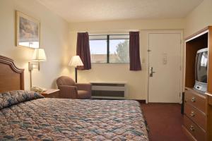 a hotel room with a bed and a television at Days Inn by Wyndham Plainfield in Plainfield