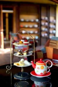 a table with three plates of desserts and a teapot at Sibsan Resort & Spa Maetaeng Chiang Mai in Mae Taeng