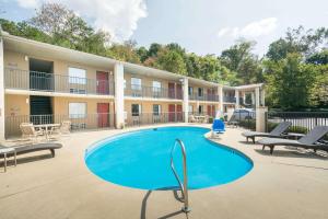 a swimming pool at a hotel with chairs and a building at Days Inn by Wyndham Asheville Downtown North in Asheville