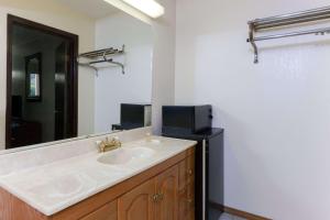 a bathroom with a sink and a black refrigerator at Days Inn by Wyndham Oklahoma City Fairground in Oklahoma City +6 photos