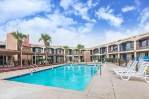 een zwembad met ligstoelen en een resort bij Days Inn by Wyndham San Antonio Splashtown/ATT Center in San Antonio