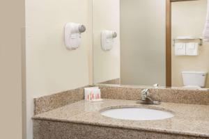 a bathroom counter with a sink and a mirror at Days Inn by Wyndham Colby in Colby