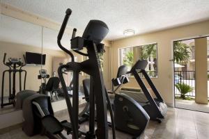 a gym with treadmills and ellipticals in a room at Days Inn by Wyndham Dallas Irving in Irving