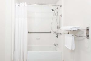 a bathroom with a shower with a shower curtain at Days Inn by Wyndham Fredericksburg North in Fredericksburg