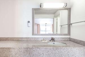 a bathroom with a sink and a mirror at Days Inn by Wyndham Fredericksburg North in Fredericksburg