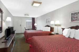 a hotel room with two beds and a flat screen tv at Days Inn by Wyndham Morristown in Morristown
