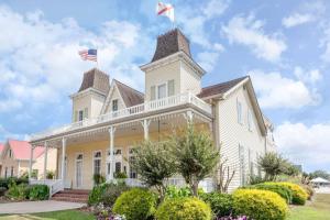 a large white house with two flags on top at Days Inn by Wyndham Cullman in Cullman