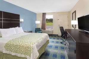 Habitación de hotel con cama y TV de pantalla plana. en Days Inn by Wyndham Newberry South Carolina, en Newberry