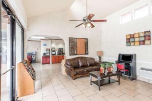 a living room with a couch and a ceiling fan at Days Inn by Wyndham San Antonio Splashtown/ATT Center in San Antonio