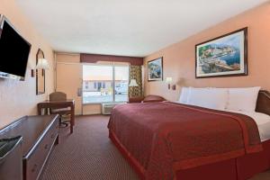a hotel room with a bed and a large window at Days Inn by Wyndham Waycross in Waycross