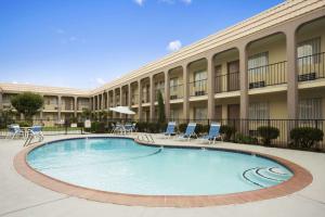 a large swimming pool in front of a building at Days Inn by Wyndham Dallas Irving in Irving