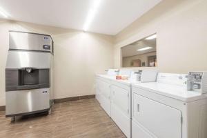 Days Inn by Wyndham San Antonio Splashtown/ATT Center في سان انطونيو: مطبخ مع دواليب بيضاء واجهزة ستانلس ستيل