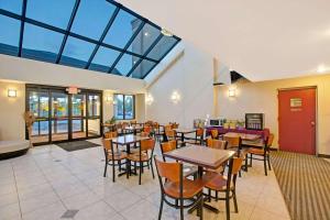 a dining room with tables and chairs and windows at Days Inn by Wyndham Parsippany in Parsippany