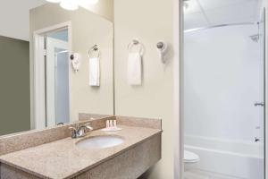 a bathroom with two sinks and a mirror at Days Inn by Wyndham Windsor Locks / Bradley Intl Airport in Windsor Locks