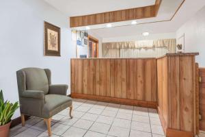una sala de espera con una silla y una pared de madera en Days Inn by Wyndham Mt. Sterling, en Mount Sterling