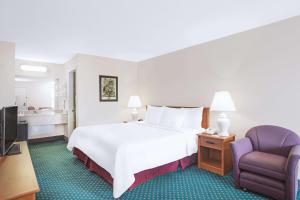 Habitación de hotel con cama y silla en Days Inn by Wyndham Wytheville, en Wytheville