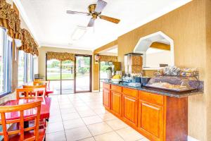 a kitchen with a ceiling fan and some chairs at Days Inn by Wyndham Chesapeake in Chesapeake