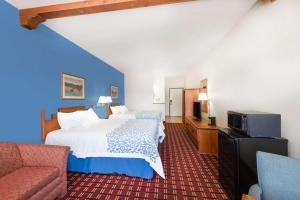 Una habitación de hotel con una cama y un televisor. en Days Inn & Suites by Wyndham Lordsburg, en Lordsburg