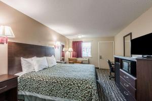 a hotel room with a bed and a flat screen tv at Days Inn by Wyndham San Marcos in San Marcos