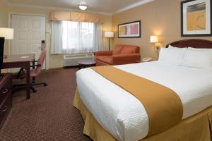 una camera d'albergo con un grande letto e una scrivania di Days Inn by Wyndham Pinole Berkeley a Pinole