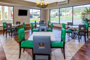 a restaurant with green chairs and tables and windows at Days Inn by Wyndham Dalton in Dalton