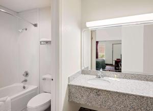 a bathroom with a sink and a toilet and a mirror at Days Inn by Wyndham Cleveland TN in Cleveland