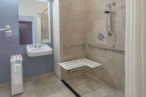 a bathroom with a shower, sink, and toilet at Days Inn by Wyndham Minot in Minot