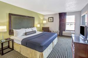 um quarto de hotel com uma cama e uma televisão em Days Inn by Wyndham Great Lakes - N. Chicago em North Chicago