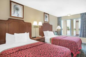 Habitación de hotel con 2 camas con sábanas rojas en Meridian Inn Hotel en Meridian