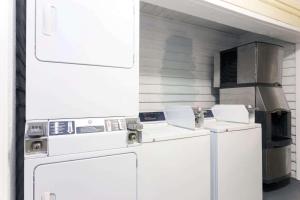 a kitchen with white washers and a stove at Days Inn by Wyndham Savannah Airport in Savannah