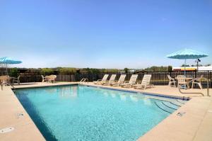 a swimming pool with lounge chairs and an umbrella at Days Inn by Wyndham Columbus-North Fort Moore in Columbus