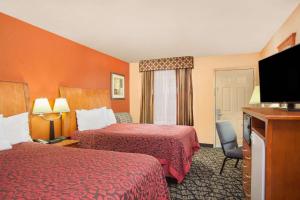 a hotel room with two beds and a flat screen tv at Days Inn by Wyndham Centerville in Centerville