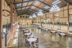 Großes Zimmer mit Tischen, Stühlen und Kronleuchtern in der Unterkunft Days Inn by Wyndham Lubbock South in Lubbock