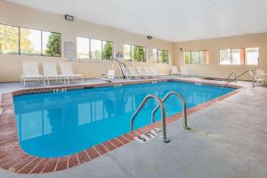 a pool at a hotel with chairs around it at Days Inn & Suites by Wyndham Peachtree Corners Norcross in Norcross