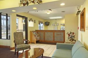 a waiting room with a couch and a chair and a table at Days Inn by Wyndham Ocean Springs in Ocean Springs