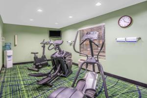 einen Fitnessraum mit zwei Heimtrainern und einer Uhr in der Unterkunft Days Inn by Wyndham Lubbock South in Lubbock