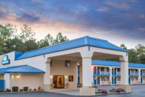 a hotel building with a blue roof at Days Inn by Wyndham Picayune in Picayune