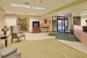 a lobby with a waiting area with chairs and a table at Days Inn by Wyndham Cleveland Lakewood in Lakewood