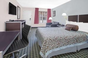 Habitación de hotel con cama y escritorio en Days Inn by Wyndham Market Center Dallas Love Field, en Dallas