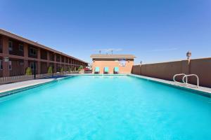 a large swimming pool on the side of a building at Days Inn by Wyndham Chowchilla Gateway to Yosemite in Chowchilla