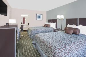a hotel room with two beds and a television at Days Inn by Wyndham Market Center Dallas Love Field in Dallas
