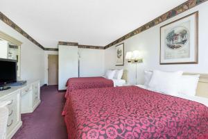 a hotel room with two beds and a flat screen tv at Days Inn by Wyndham Concordia in Concordia