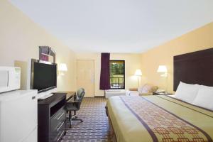 Days Inn by Wyndham Andalusia في أندلوسيا: غرفة فندقية بسرير وتلفزيون بشاشة مسطحة