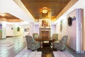 a lobby with a table and chairs and a fireplace at Days Inn & Suites by Wyndham Ridgeland in Ridgeland